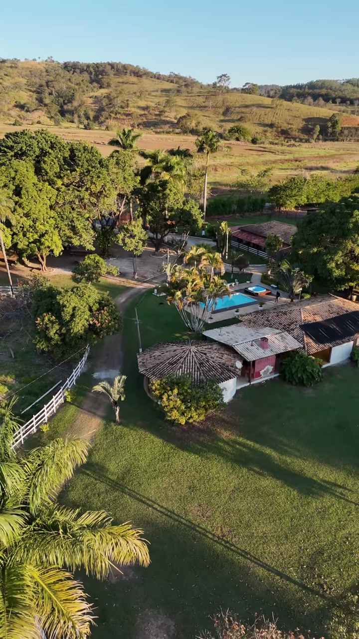 Vista aérea do Rancho Nhá Chica, com jardins, piscina e construções cercadas pela natureza